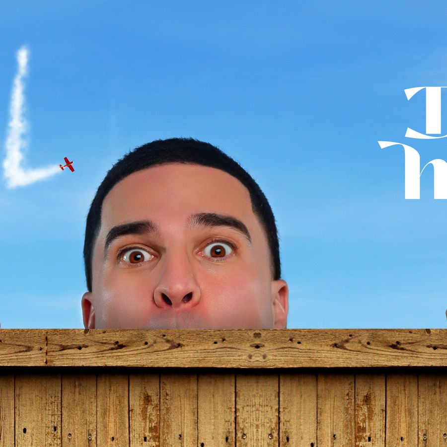 Nabil zijn hoofd komt net over een houten randje tevoorschijn. Hij houdt zich daaraan vast en ziet zijn vingers over het randje komen. Boven zijn hoofd is de blauwe lucht te zien met de witte tekst van een vliegtuig: Nabil. Daarnaast staat een witte tekst: Daar is hij weer.