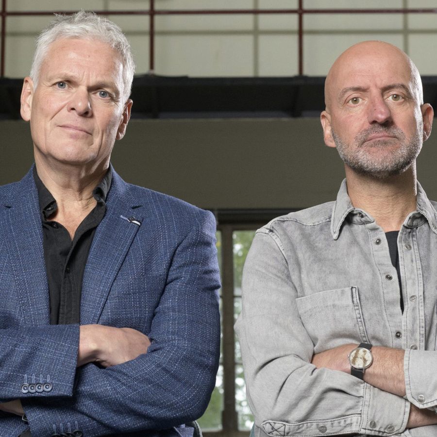 Twee mannen met hun armen over elkaar kijken serieus naar de camera.