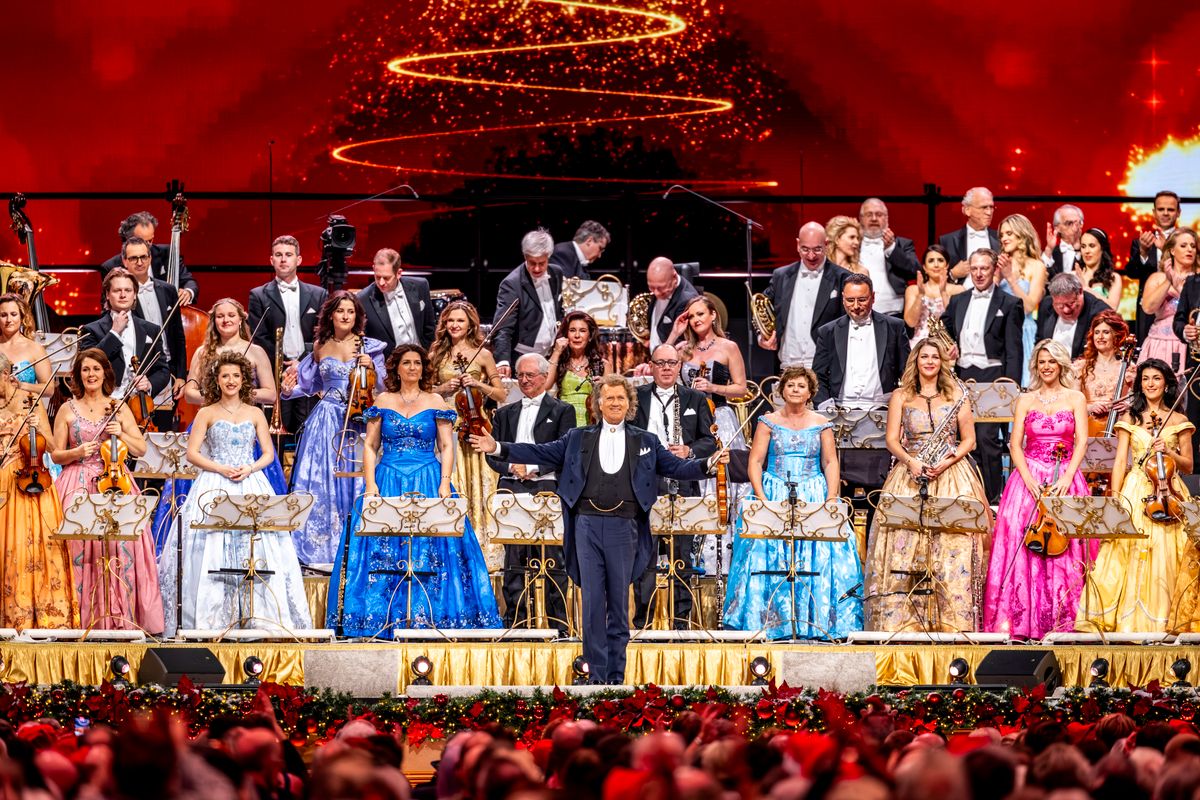 André Rieu omringt door zijn orkest en zangeressen. 