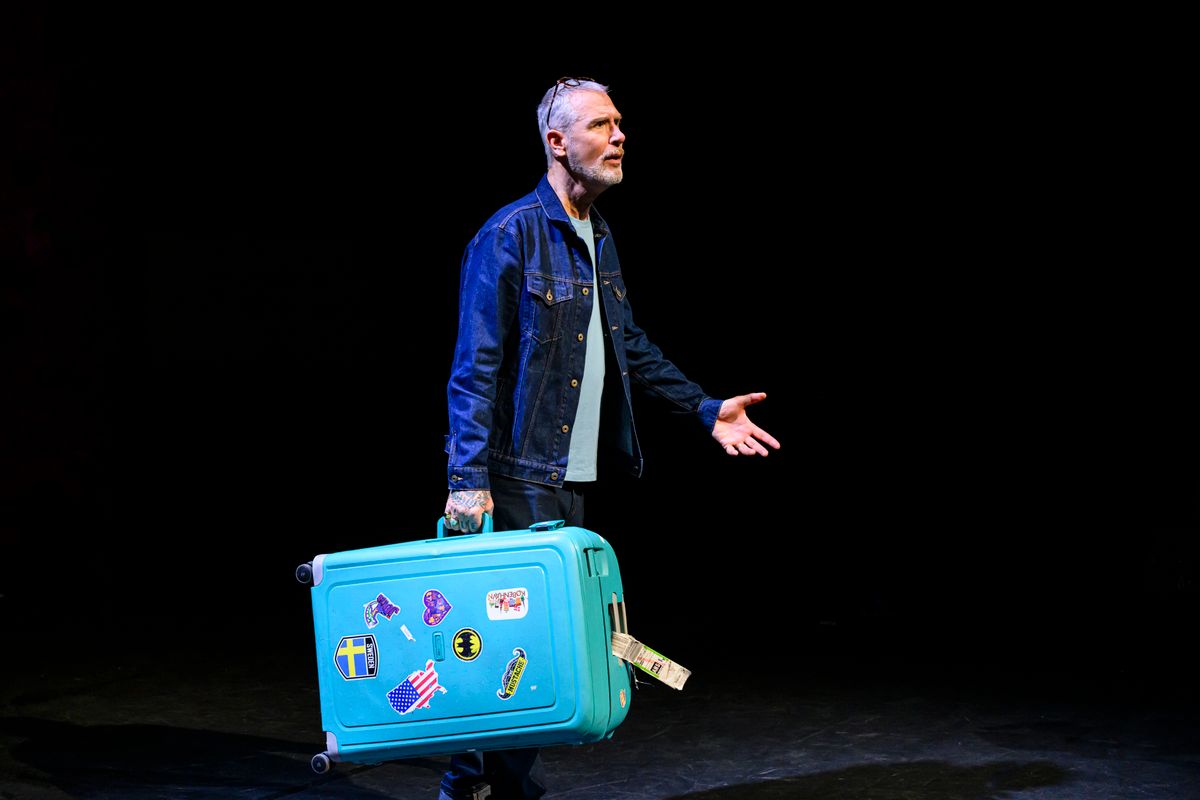 Een man houdt een koffer in zijn hand en kijkt verbaast 