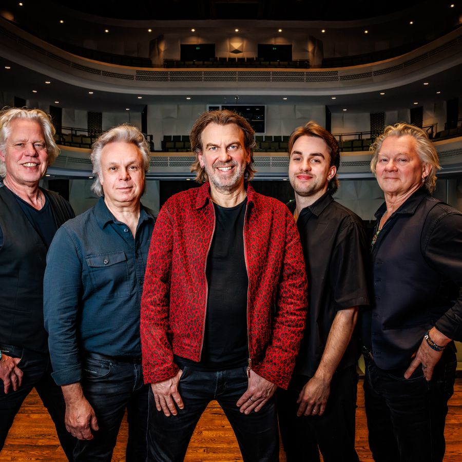 De 5 bandleden van Coming On Strong  naast elkaar staand op het podium met  hun rug naar de theaterzaal.