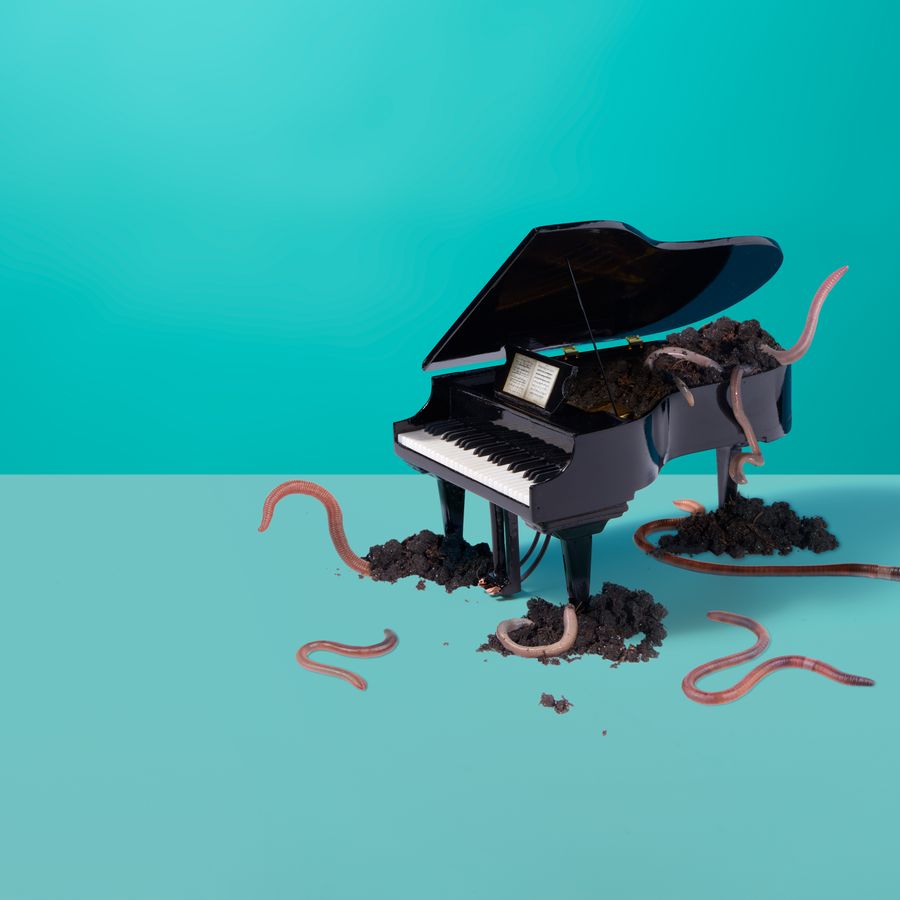 Een piano waar wormen uit komen met een blauwe achtergrond.