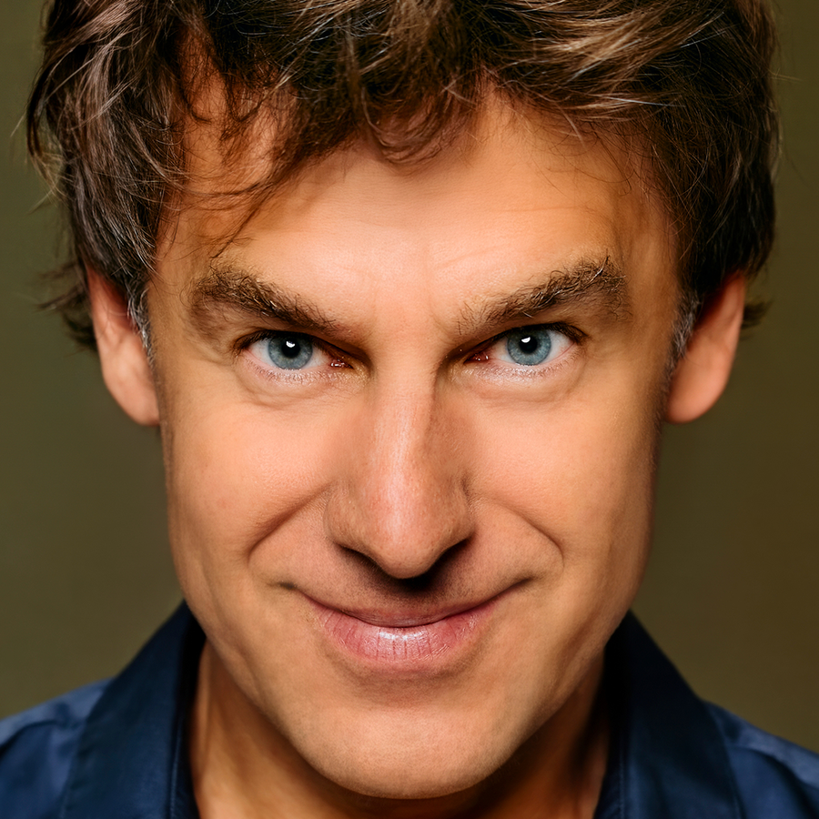 Remko kijkt half naar beneden met zijn ogen gericht op de camera en hij heeft een kleine glimlach.
