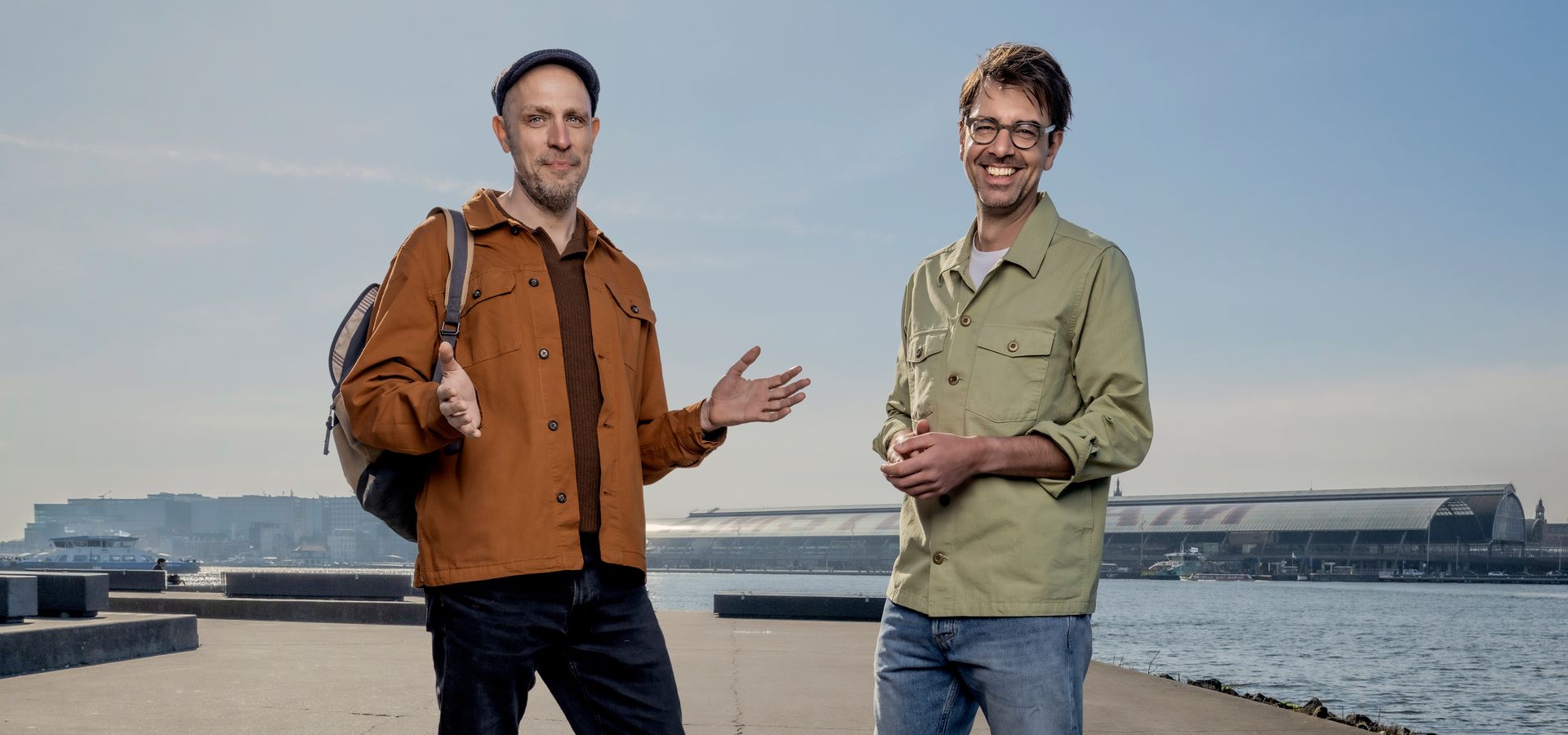De heren Ruben Terlou en Jelle Brandt Corstius staan naast elkaar op een dijk. 