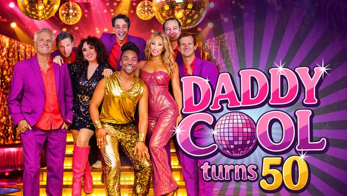 Een groep mensen van 8 mensen staan in glitterpakjes op een disco vloer met disco ballen in de lucht. Op de achtergrond is een gouden trap te zien. De man in het midden is als enige in een gouden glitterpak. De rest van de mannen hebben een paarse pak aan en twee vrouwen hebben een glitterjurk aan. Rechts van de foto staat de tekst: daddy cool turns 50.
