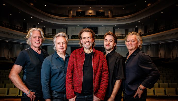 De 5 bandleden van Coming On Strong  naast elkaar staand op het podium met  hun rug naar de theaterzaal.