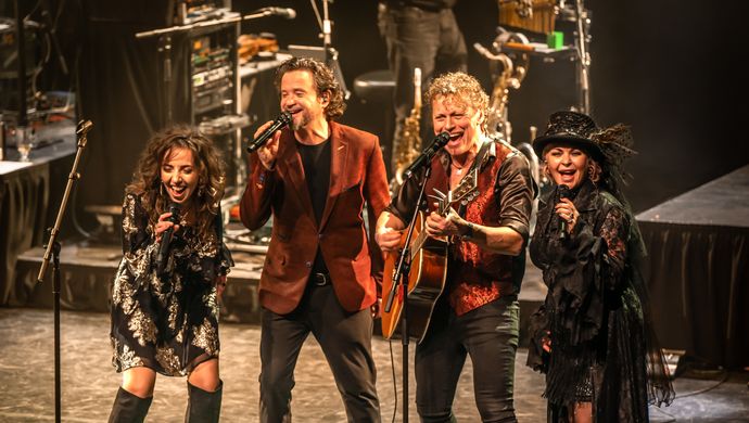 4 muzikanten/zangers on stage zingend. 