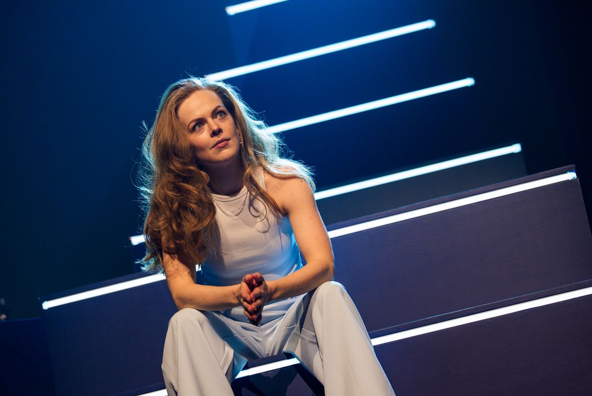 Lisa Ostermann zit op een trap en kijkt opzij. Ze kijkt serieus