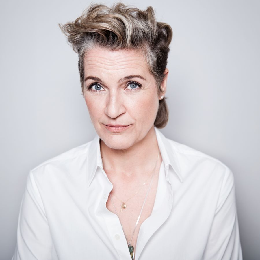 Margriet staat voor een grijze achtergrond en kijkt met een blik van twijfel naar de camera. Haar wenkbrauwen staan omhoog.