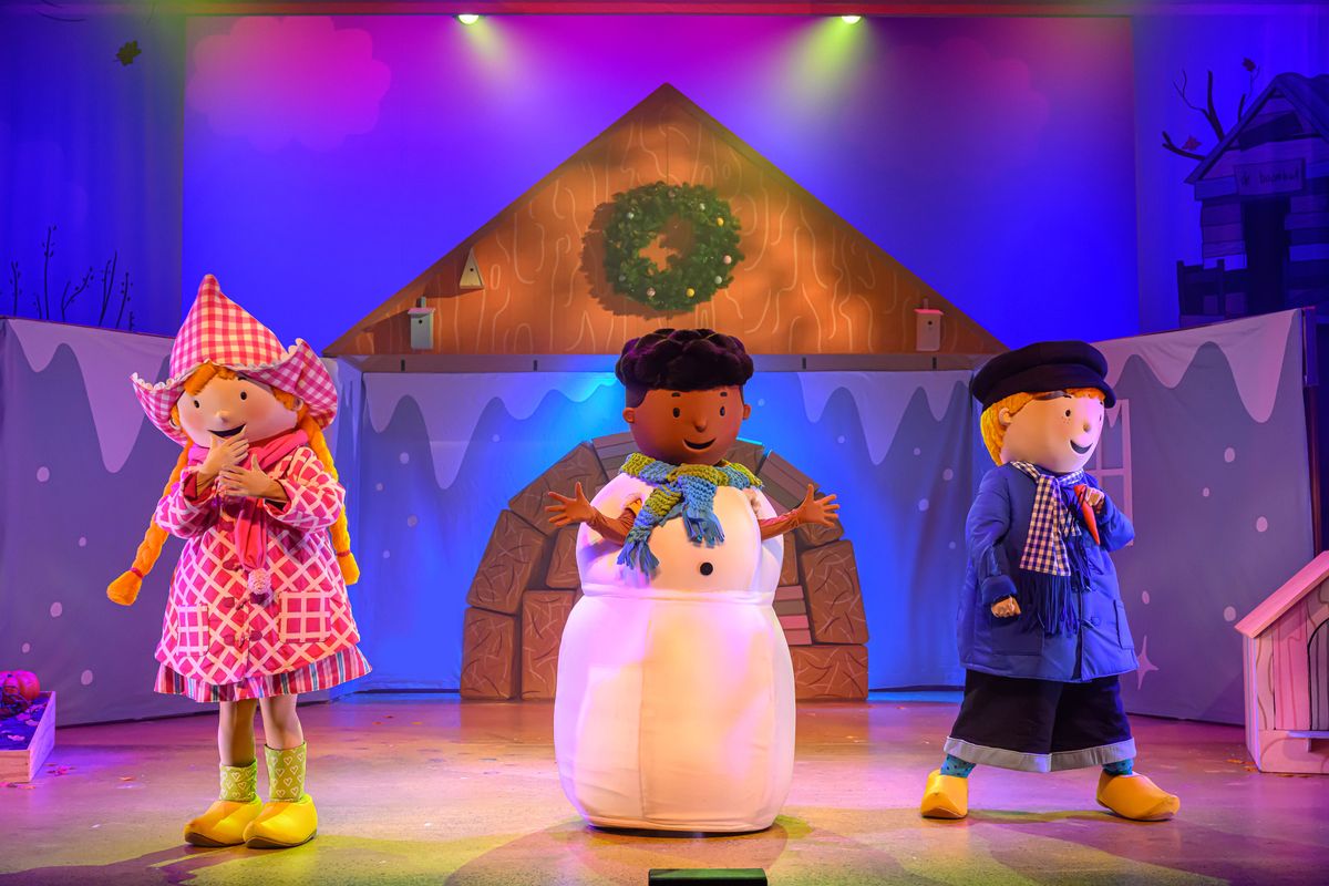 Fien en Teun als poppen staan voor een huis met in het midden nog een pop verstopt in een sneeuwpop.