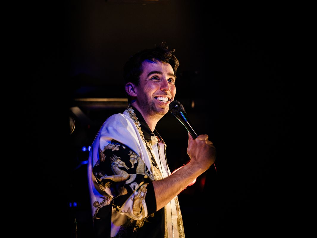 Man houdt lachen een microfoon voor zijn mond